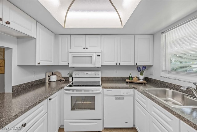 kitchen featuring sink, white cabinets, and white appliances