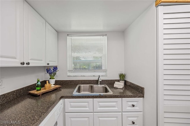 kitchen with white dishwasher, sink, and white cabinets