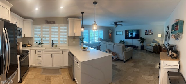 3680 Woodstork Ct, Fort Myers, FL 33908 - kitchen with open floor plan, a peninsula, black appliances, and stone tile flooring