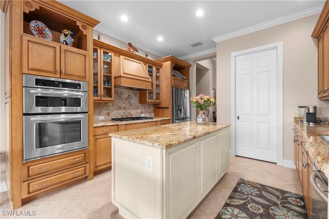 kitchen with stainless steel appliances, light stone countertops, decorative backsplash, crown molding, and custom exhaust hood