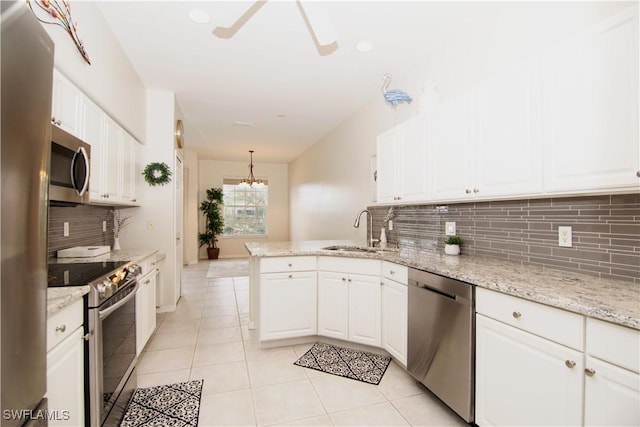 kitchen featuring white cabinetry, appliances with stainless steel finishes, a sink, and decorative light fixtures