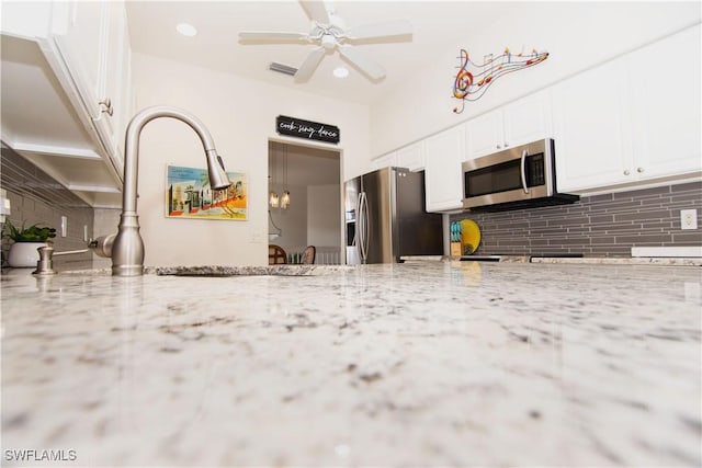 10007 Sky View Way Unit 2005, Fort Myers, FL 33913 - kitchen with stainless steel appliances, tasteful backsplash, white cabinets, light stone counters, and recessed lighting