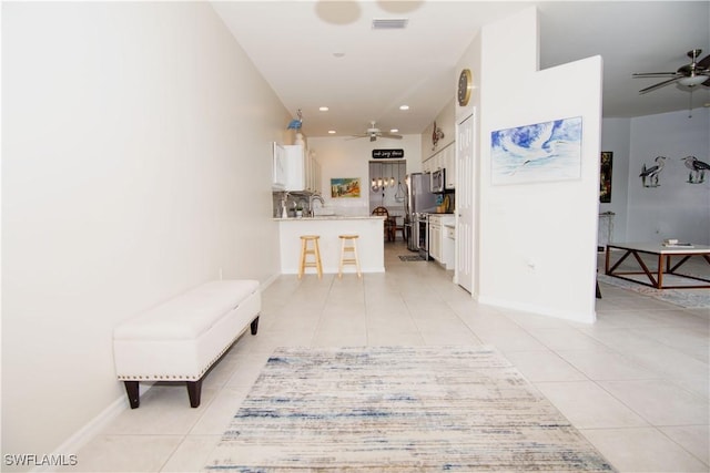 hallway with sink and light tile patterned flooring