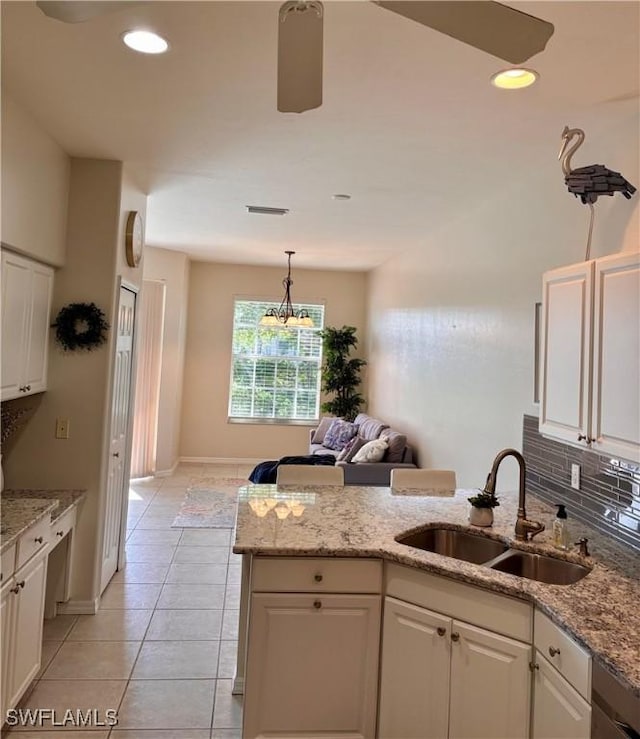 10007 Sky View Way Unit 2005, Fort Myers, FL 33913 - kitchen with white cabinetry, a peninsula, light tile patterned floors, light stone counters, and recessed lighting