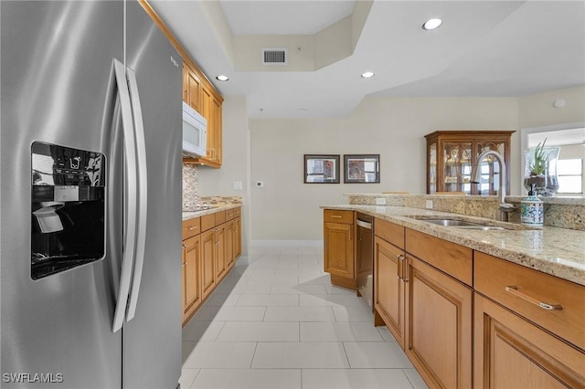 kitchen featuring recessed lighting, a sink, visible vents, light stone countertops, and appliances with stainless steel finishes