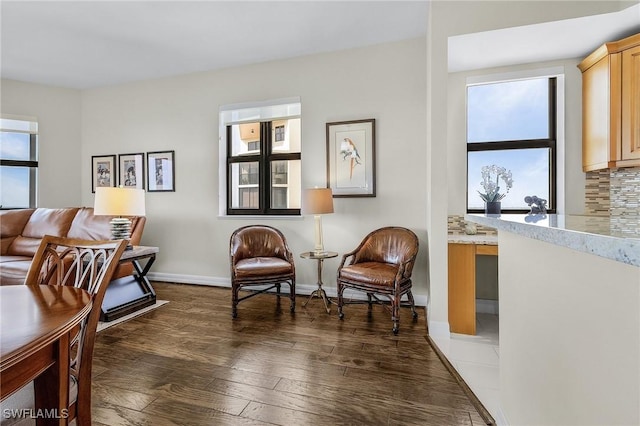 sitting room with plenty of natural light, baseboards, and dark wood finished floors