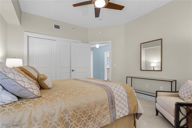 carpeted bedroom with visible vents, a closet, and a ceiling fan