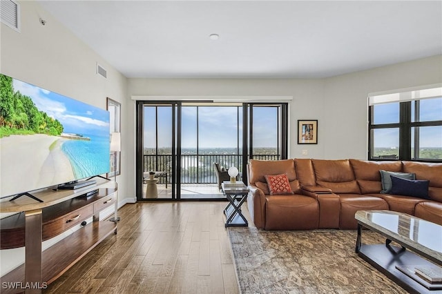 living area with visible vents, baseboards, and wood finished floors