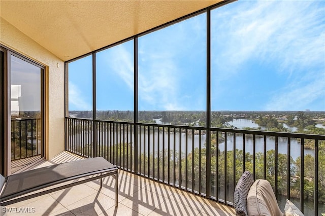 unfurnished sunroom featuring a water view