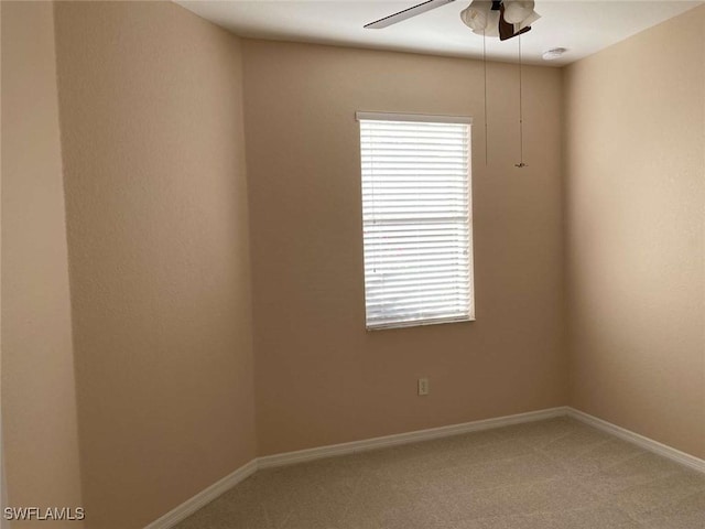 carpeted spare room with ceiling fan