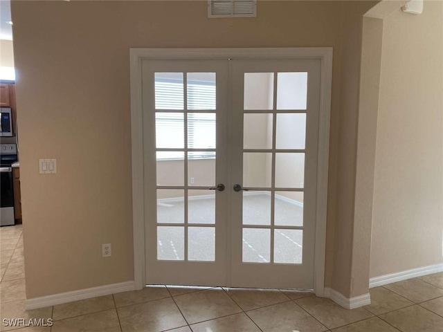 entryway featuring light tile patterned floors and french doors