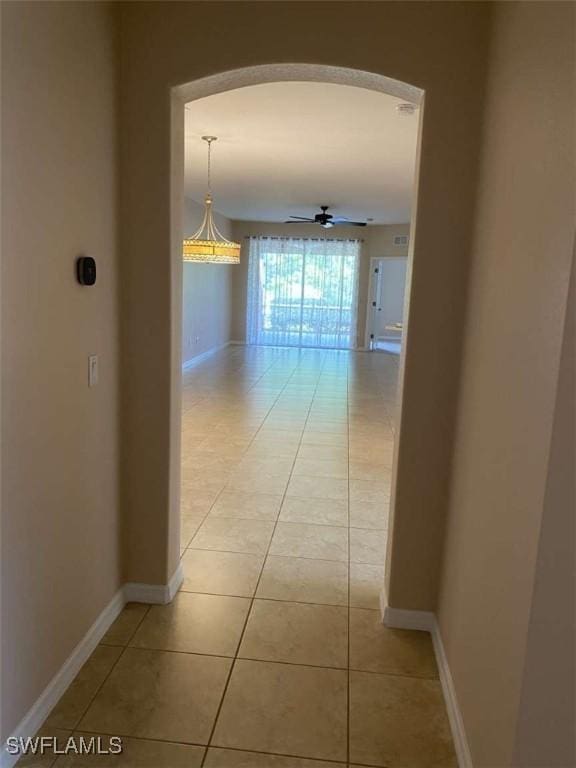 13772 Cleto Dr, Estero, FL 33928 - corridor featuring baseboards, arched walkways, and light tile patterned flooring