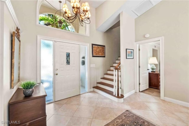 foyer entrance with stairway, light tile patterned flooring, a towering ceiling, and baseboards