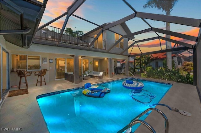 pool with outdoor lounge area, a patio area, and a lanai