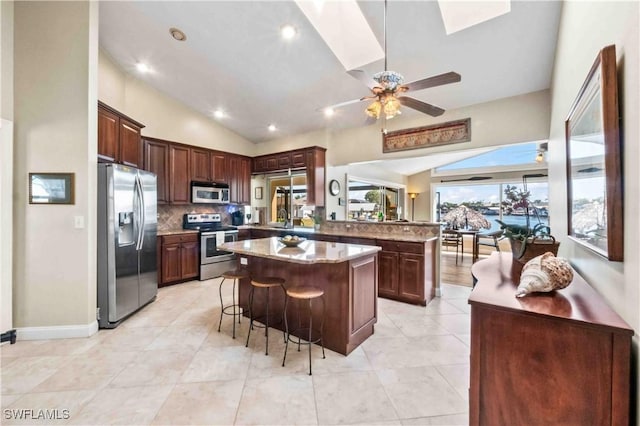 kitchen featuring appliances with stainless steel finishes, lofted ceiling, ceiling fan, and a peninsula