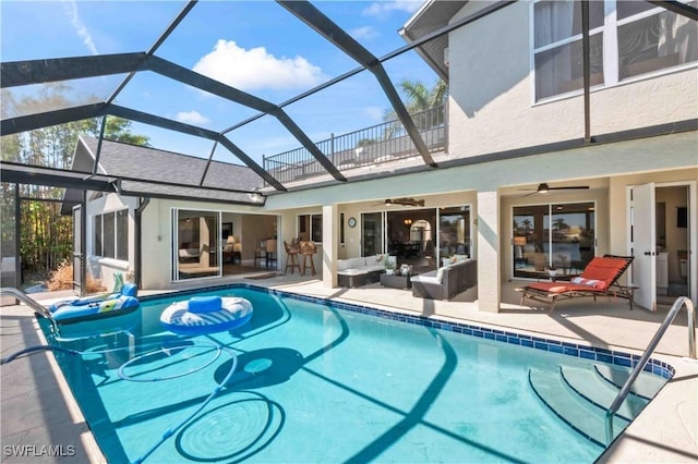 pool with a ceiling fan, glass enclosure, a patio area, and an outdoor living space