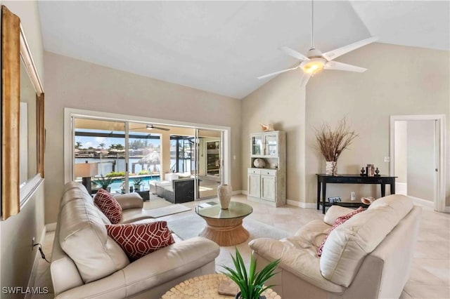 living area with ceiling fan, high vaulted ceiling, light tile patterned floors, and baseboards