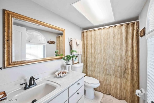 bathroom with tile patterned flooring, vanity, and toilet