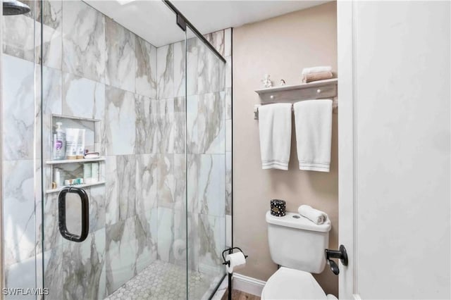 bathroom featuring a stall shower and toilet