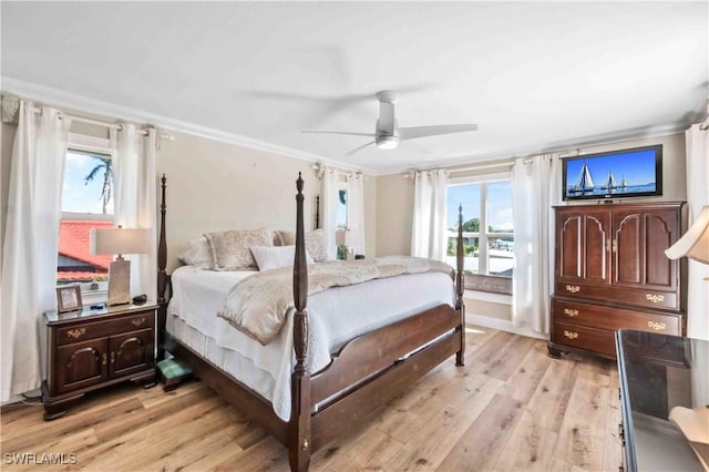 bedroom with light wood-type flooring, a ceiling fan, and crown molding