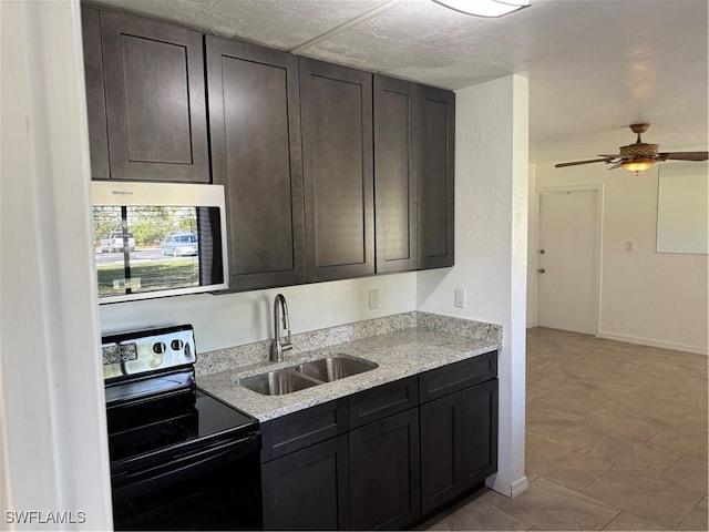 kitchen featuring black electric range, sink, dark brown cabinets, and light stone counters