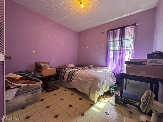 bedroom featuring vaulted ceiling and a textured ceiling