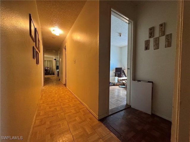 hallway with light parquet floors and a textured ceiling