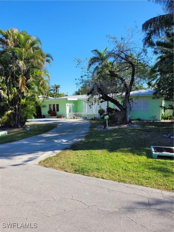 single story home featuring driveway and a front yard