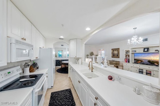 kitchen with pendant lighting, sink, white cabinets, light tile patterned floors, and white appliances