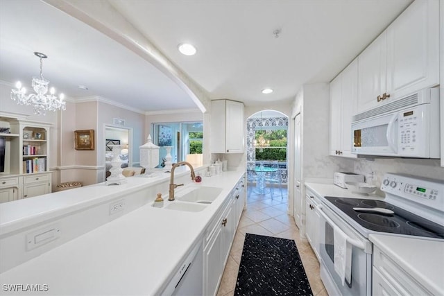 kitchen featuring white cabinetry, sink, hanging light fixtures, ornamental molding, and white appliances