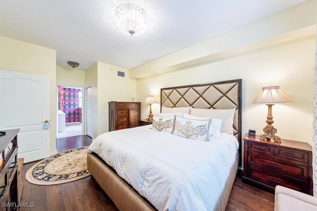 bedroom featuring dark wood-type flooring and ensuite bath