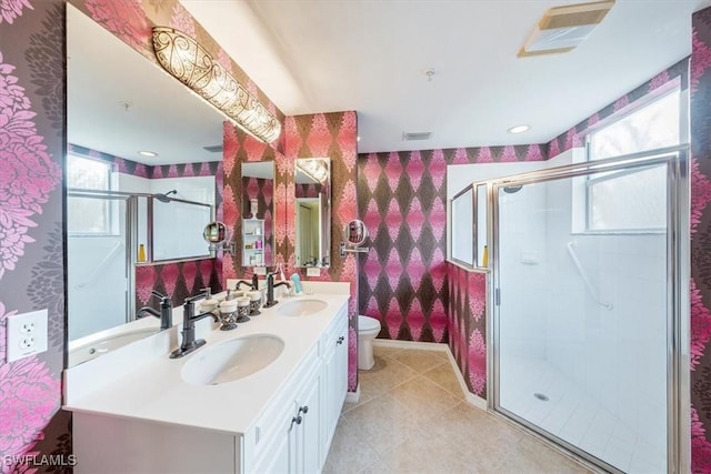 bathroom featuring plenty of natural light, toilet, a shower with door, and vanity