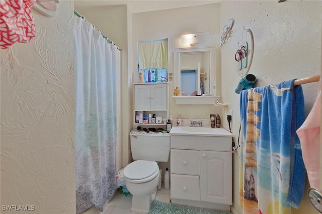 bathroom featuring vanity, tile patterned floors, and toilet