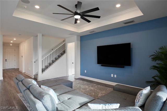 living room with a raised ceiling and hardwood / wood-style floors