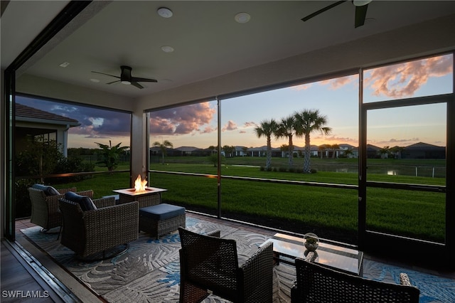 sunroom / solarium with an outdoor living space with a fire pit and ceiling fan