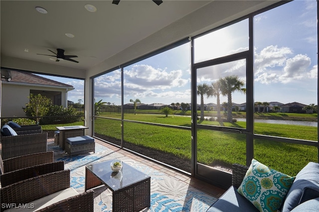 sunroom / solarium featuring a water view and ceiling fan