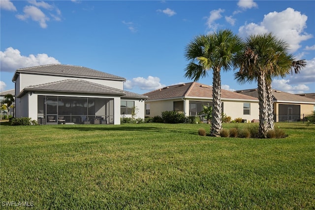 back of property with a yard and a sunroom