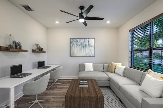 home office with built in desk, dark hardwood / wood-style floors, and ceiling fan