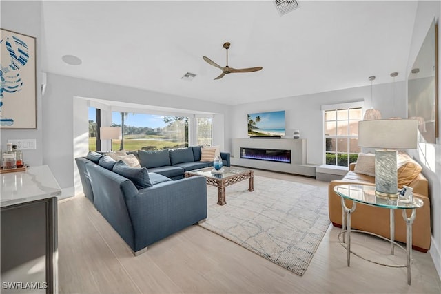 living room with plenty of natural light, ceiling fan, and light hardwood / wood-style floors