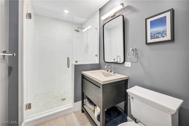 bathroom featuring hardwood / wood-style flooring, toilet, vanity, and walk in shower