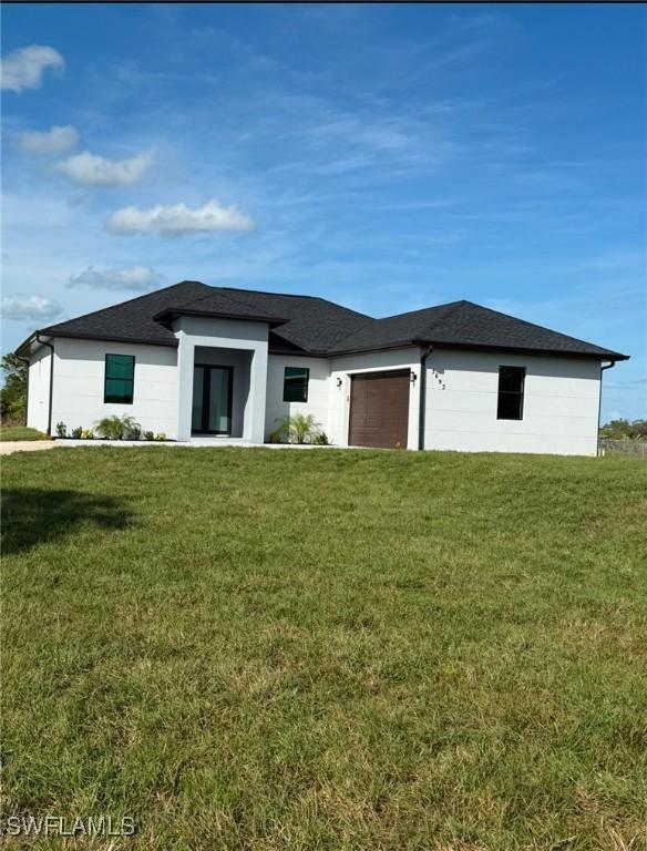 view of front of house with a front yard and a garage