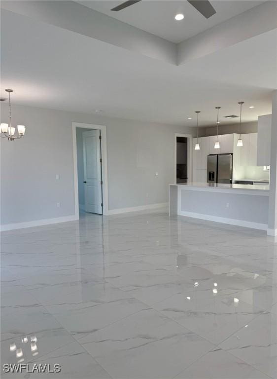 unfurnished living room featuring a tray ceiling and a notable chandelier