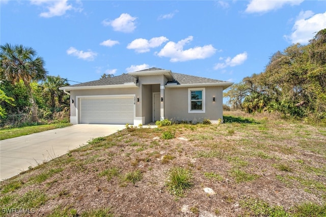 view of front of home with stucco siding, concrete driveway, and an attached garage