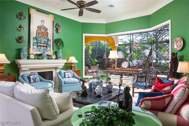 living area with ceiling fan and ornamental molding