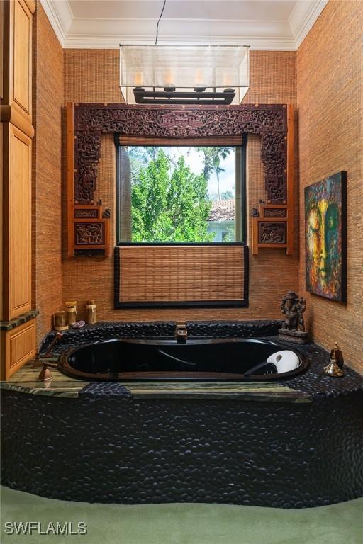 bathroom with tiled bath and crown molding