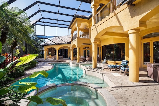 view of swimming pool with a patio, an in ground hot tub, ceiling fan, and glass enclosure