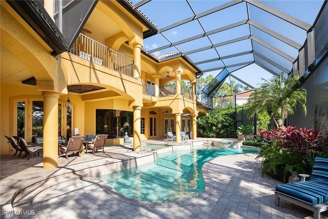 view of swimming pool featuring a patio area, ceiling fan, and a lanai