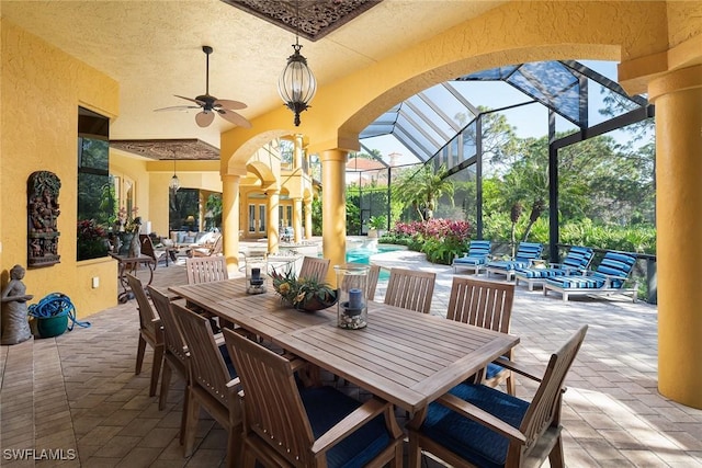 view of patio with outdoor lounge area, ceiling fan, and glass enclosure