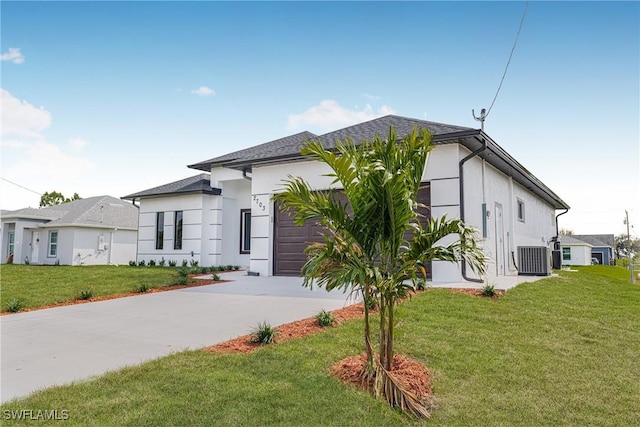 view of front of house featuring cooling unit, a garage, and a front yard