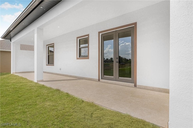 back of property with a yard, a patio, and french doors